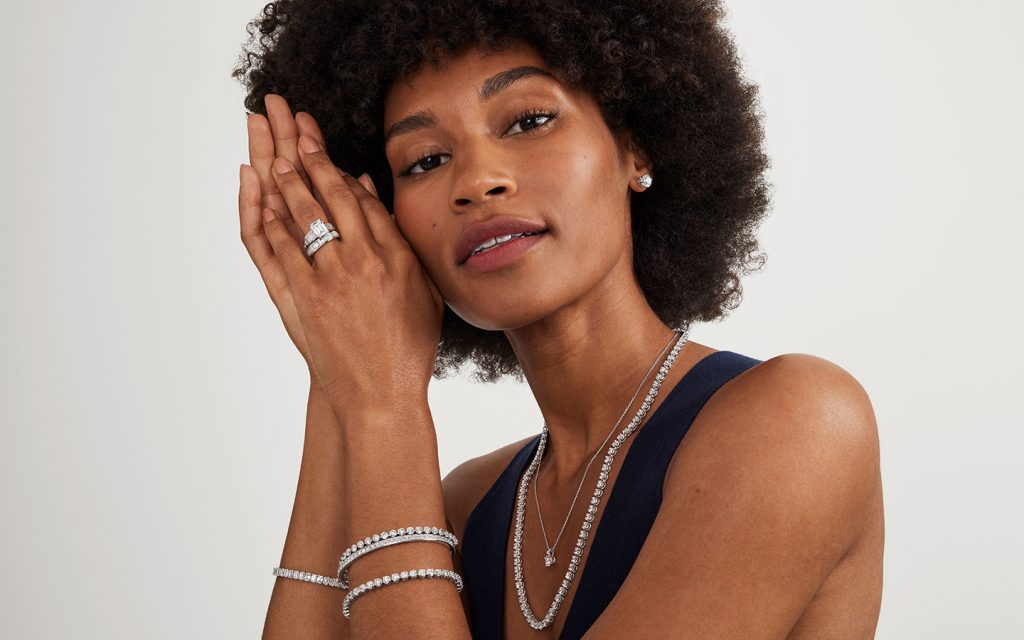 Woman wearing diamond jewelry including soldered rings.